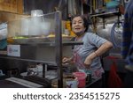 Small photo of Singapore - November 13, 2022 : Through a candid perspective, the bustling scenes of Boon Keng Hawker Center in Singapore come alive, capturing the rich tapestry of daily moments and flavors