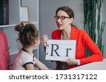 Small photo of Speech therapist teaches the girls to say the letter R. Female Speech Language Therapist Teaching Preschool Kid Sound Pronunciation, Stuttering Cute Child Having Stutter.
