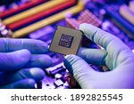 Laboratory technician holds a powerful processor in his hands. CPU computer processor shallow focus. CPU socket of the computer's motherboard. Concept of computer, motherboard, hardware and technology