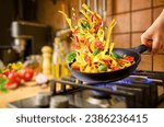 Preparing Italian pasta with vegetables in a frying pan on the gas stove for evening dinner at home kitchen