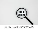 Small photo of A concept image of a magnifying glass isolated white background with a word FREE COURSE zoom inside the glass
