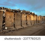 Small photo of A pile of metall car components in concrete pillars enclosure, thrash and waste from factory industrial, crash tested, recycling