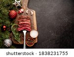 
Different degrees of roasting of steak on a meat fork for Christmas on a background of a stone with a spruce and Christmas toys with copy space for your text
