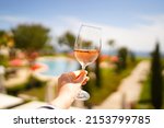 Small photo of Female hand with glass of r wine. Cozy hotel on the coast of Lagos. Sea view, beautiful landscape in Portugal Adventure in Europe (travel photo).