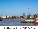 London cityscape seen from the River Thames with cloudless sky, including Tideway East Project Office, Guy's Hospital, The Shard and Wapping Police Boatyard
