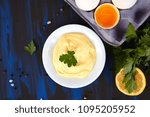 Small photo of Homemade sauce Mayonnaise and ingredients eggs, oil, lemon, mustar on dark blue background. Top view
