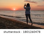 woman looking at sunset standing at sea beach