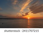 The setting sun and evening clouds over the River Humber near Paull, East Riding of Yorkshire, England, UK