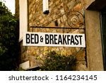 Vintage Bed & Breakfast Sign Attached To Rustic Brick Building In English Village