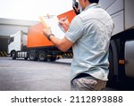 Small photo of Truck Driver is Checking the Truck's Safety Maintenance Checklist. Lorry. Inspection Semi Truck Wheels and Tires. Warehouse Cargo Shipping. Loading Freight Truck Transport Logistics.