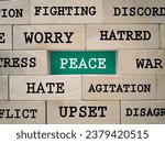 Small photo of Motivational and inspirational wording. Peace concept. PEACE WORD and it’s antonym words written on wooden blocks. With blurred styled background.