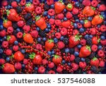 Berries overhead closeup colorful assorted mix of strawberry, blueberry, raspberry, blackberry, red currant in studio on dark background