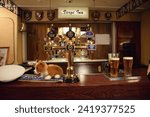 Small photo of Edinburgh, Scotland August 15 2017: vintage bar with beer taps, beer glasses and stuffed plush corgi animal with sign of Verge Inn aboard the HM Brittania Royals yacht in Edinburgh, Scotland