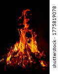 Small photo of Burning wood at night. Bonfire in a tourist camp in nature in the mountains. Flames and fire sparks on a dark abstract background. Outdoor barbecue. The infernal element of fire. Fuel, power and energ