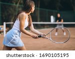 Young woman playing tennis at...