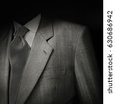 Small photo of Black & White film photo of man suit detail against black background. Low key exposure to give it a sinister and dark semblance.