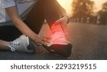 Small photo of Ankle twist sprain accident in sport exercise running jogging.low key lighting.