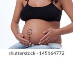 Small photo of The tummy of a woman far gone with child, having the Venus sign playfully drown around the navel, hand on her abdomen.