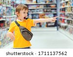 Small photo of Boy screams and demands a toy in the store. Little boy getting hysterical in toy shop. ?hildren's tantrum in the store. Shop toys. Inside toy shop. Kid makes difficult choice in supermarket.