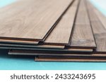 Small photo of Laminate with a pattern and wood texture for flooring and interior design. Installing laminate flooring. Installing laminated floor, detail on wooden tiles ready to be fit. Laminate background.
