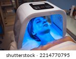 Small photo of LED red light is treating the facial skin of a young woman. High quality 4k footage