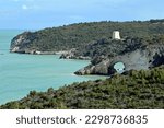 Small photo of View of the Arch of San Felice in Gargano, Italy, and the Tower of San Felice, over a teal sea