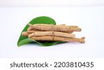 Small photo of Ashwagandha Dry Root Medicinal Herb with Fresh Leaves, also known as Withania Somnifera, Ashwagandha, Indian Ginseng, Poison Gooseberry, or Winter Cherry. Isolated on White Background.