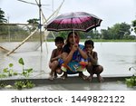 Small photo of Barpeta, Assam, India. July 12, 2019. Woman and children take shelter on a height in the flood effected Kalgachia of Barpeta.