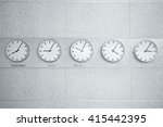 Five wall clocks showing time in different capitals of the world.