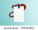 Blank badge mockup isolated on blue background. Plain empty name tag mock up with red string.