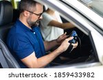 Professional car mechanic repair service and checking car engine by Diagnostics Software computer. Expertise mechanic working in automobile repair garage. 