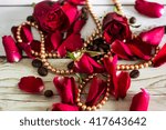 Pentals of red roses and a necklace