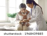 Caring doctor teaches female patient to use mobile healthcare app. Retired lady sitting in hospital exam room looking at cell screen learning to download health tracker for senior citizens. Copy space