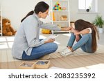 Small photo of Sympathetic young female specialist trying to help sad, stressed, depressed child with behaviour issues and cognitive disorders overcome negative emotions, develop skills and solve learning problems