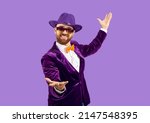 Small photo of Portrait of smiling man performer in disco jacket isolated on purple studio background make tricks. Happy male entertainer or party man in suit and hat communicate with audience. Party concept.