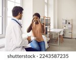 Small photo of Unhealthy young African American woman complain on headache or migraine at consultation with doctor in clinic. Male therapist consult black female patient with dizziness. Healthcare and medicine.