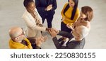 Small photo of Group of cheerful positive diverse multiethnic people meeting and getting acquainted at casual business event. Young black woman feeling at ease and exchanging handshake with senior man. High angle