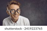Small photo of Closeup studio portrait of funny nerd wearing retro vintage thick rimmed glasses on copyspace background. Happy young man in uncool old-fashioned round frame spectacles looking at camera and smiling