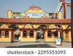 Small photo of Buena Park, California - USA - April - 27-2023: Knott's Berry Farm. Knotts Berry Farm entrance and ticket booths. Entrance Gates with Roller Coaster Rides in the background. A Fun Time had for all.