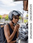 Woman wearing motorcycle helmet ...