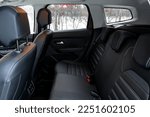 Modern car interior. Clean rear seats with the belts. Three rear seats in the row.  Leather light back passenger seats.
