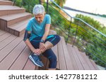 Small photo of Senior Woman in pain while running in park, knee injury. Senior woman with an expression of severe pain in her leg. Athlete woman has calf crump, pain in leg during running