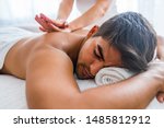 Small photo of Man having massage in spa salon, closeup. Sports massage. Massage therapist massaging shoulders of a male athlete, working with Trapezius muscle. Young Man Enjoying Massage At Spa
