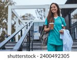 Hardworking mid adult beautiful nurse climbs the stairs to her apartment after a hard day at work. Portrait of happy young female nurse. A female healthcare worker leaving the house in her uniform.