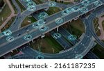 Small photo of Aerial view: Self-driving autonomous electric cars of the future with HUD elements move along a busy traffic intersection. Concept: Artificial Intelligence, Car Scan, GPS Tracking, Smart Roads, IoT.