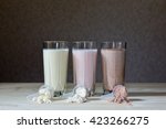 Fresh milk, chocolate, blueberry and banana drinks on table, assorted protein cocktails.