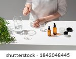 Small photo of The scientist, dermatologist testing the organic natural cosmetic product in the laboratory. Vials, glass laboratory flasks. Beauty cosmetic research and development concept.