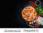 Traditional Italian pizza, vegetables, ingredients on a dark metallic background. Pizza is cooking in the oven. Pizza menu. View from above. Space for text.