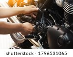 mechanic hold Hex Key Wrench working on motorcycle at motorbike garage , concept of motorcycle maintenance and repair.selective focus                         