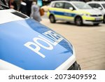 Small photo of German police cars on the street. Side view of a police car with the lettering "Polizei". Police patrol car parked on the street in Germany.